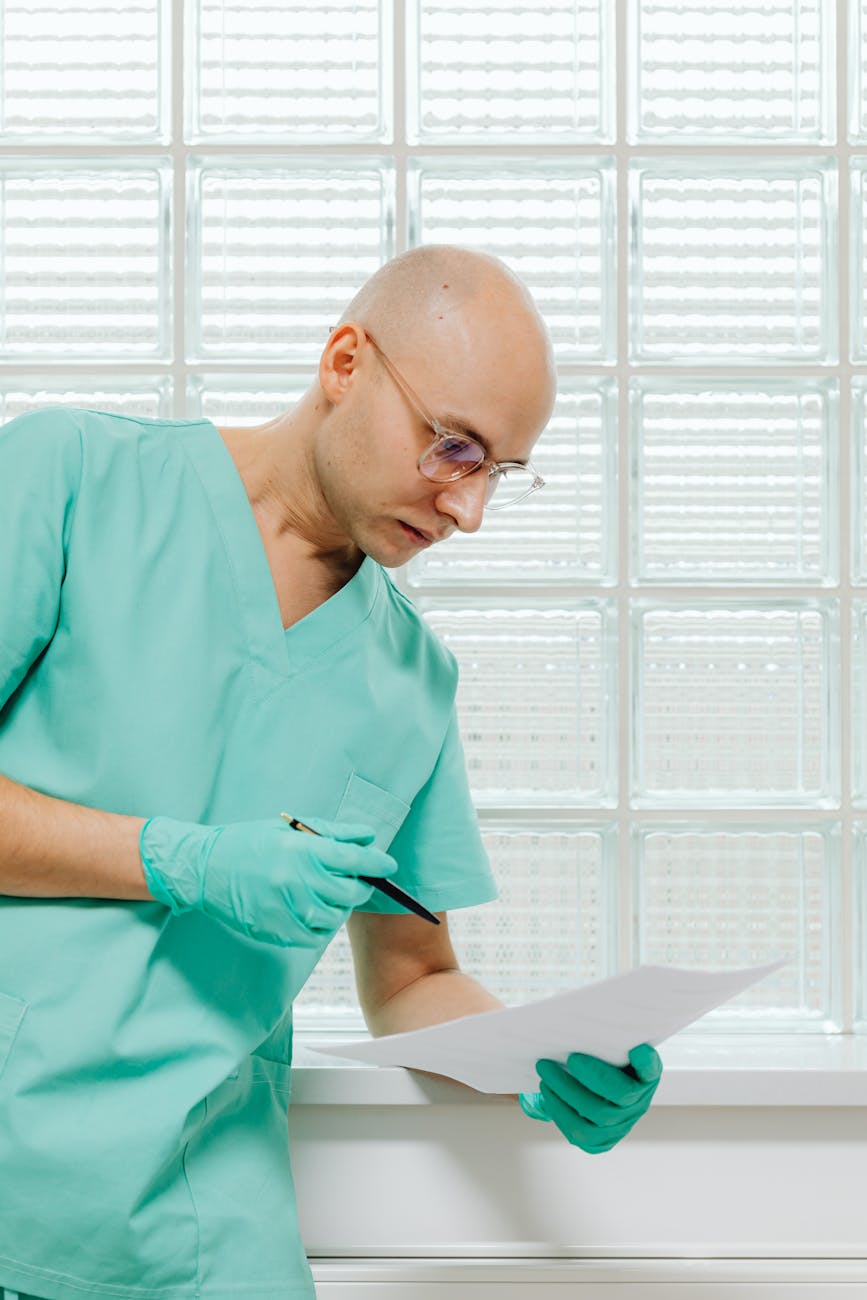 Professional healthcare provider reviewing patient charts and medical documentation, demonstrating the clinical expertise and attention to detail that defines quality nursing care